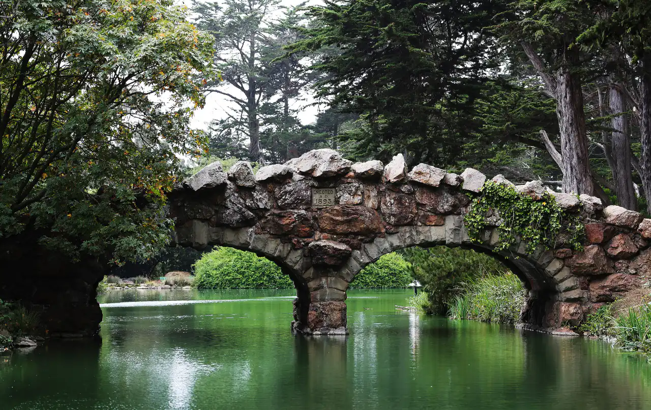 The arched stone Rustic Bridge reflected in Blue Heron Lake